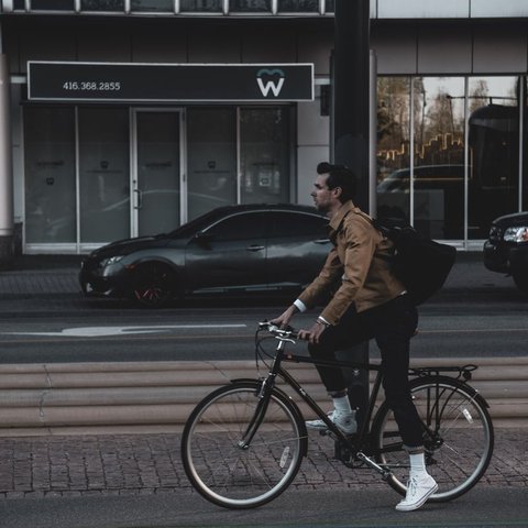 Man riding a bicycle on a city street at dusk